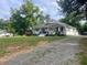 Charming one-story home with a covered front porch and a gravel driveway at 2037 Swepsonville Rd, Graham, NC 27253