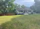 Cozy one-story home with a covered front porch surrounded by a lush lawn at 2037 Swepsonville Rd, Graham, NC 27253