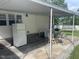 Covered patio with an outdoor dining area and a white refrigerator at 2037 Swepsonville Rd, Graham, NC 27253