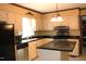 Quaint kitchen features updated appliances, warm cabinetry and a center island with granite countertop at 2071 Meadow Ln, Graham, NC 27253