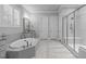 Modern bathroom features a soaking tub and walk-in shower with gray tile and neutral paint at 2121 Vecchio Ln, Apex, NC 27502