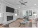 Bright living room boasts a fireplace with built-in shelving and a modern ceiling fan at 2121 Vecchio Ln, Apex, NC 27502