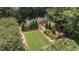 Aerial view of a charming home with a lush lawn, surrounded by trees and well-maintained landscaping at 2283 Mays Chapel Rd, Sanford, NC 27330