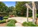 Beautifully landscaped backyard with pergola, brick accents, tiered garden, and lush greenery at 2283 Mays Chapel Rd, Sanford, NC 27330