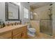 Stylish bathroom featuring a glass shower, vanity, window with blinds, and a white toilet at 2283 Mays Chapel Rd, Sanford, NC 27330