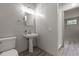 Bathroom featuring a pedestal sink, elongated toilet, decorative mirror, and a tiled walk-in shower at 2283 Mays Chapel Rd, Sanford, NC 27330