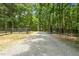 Long gravel driveway lined with trees and split rail fence leading to a private property at 2283 Mays Chapel Rd, Sanford, NC 27330