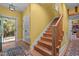 Entryway featuring a wooden staircase, yellow walls, and a view of the kitchen at 2283 Mays Chapel Rd, Sanford, NC 27330