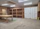 Spacious garage featuring built-in shelving, ample lighting, and a workbench area, perfect for storage and projects at 2283 Mays Chapel Rd, Sanford, NC 27330