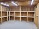 Well-lit garage features built-in wooden shelving units for storage and organization, illuminated by overhead lighting at 2283 Mays Chapel Rd, Sanford, NC 27330