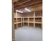 Well-lit garage features built-in wooden shelving units, ideal for maximizing storage and organization at 2283 Mays Chapel Rd, Sanford, NC 27330