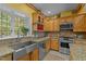 Beautiful kitchen with custom cabinets, granite countertops, stainless steel appliances, and ample natural light at 2283 Mays Chapel Rd, Sanford, NC 27330