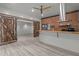 Stylishly renovated living room with sliding barn doors, ceiling fan, brick accent wall, and stylish kitchen island at 2283 Mays Chapel Rd, Sanford, NC 27330