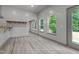 Bright living room with tile flooring, three large windows overlooking the backyard, and gray paint at 2283 Mays Chapel Rd, Sanford, NC 27330