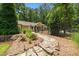 Landscaped yard featuring stone pathways, garden beds, and a charming wrought iron fence at 2283 Mays Chapel Rd, Sanford, NC 27330