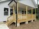Close-up of the cozy front porch with wooden railings and support beams at 2301 Pinecroft Dr, Burlington, NC 27217