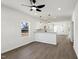 Open-concept living room with modern lighting and gray wood flooring that flows into kitchen at 2301 Pinecroft Dr, Burlington, NC 27217