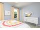 Charming bedroom with two windows, a white dresser, decor, and rainbow-themed bedding at 234 Macon Lake Drive # 39, Apex, NC 27523