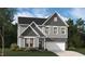 Beautiful new two story home with gray siding, stone accents, manicured lawn, and a two-car garage at 234 Macon Lake Drive # 39, Apex, NC 27523