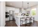 Modern kitchen features stainless steel appliances, white cabinets, and an island with seating at 242 Macon Lake Drive # 37, Apex, NC 27523