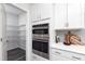 Well-lit kitchen with stainless steel double oven and white cabinets, complete with a spacious pantry at 254 Macon Lake Drive # 34, Apex, NC 27523