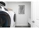 Efficient laundry area featuring modern washer and dryer, shelving, and accent art at 254 Macon Lake Drive # 34, Apex, NC 27523