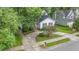 Home featuring a circular driveway with black shutters surrounded by mature trees at 2629 Hiking Trl, Raleigh, NC 27615