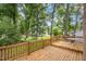 Wooden back deck with a table, perfect for outdoor relaxation amidst the lush green yard at 2629 Hiking Trl, Raleigh, NC 27615