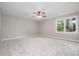 Spacious and well-lit bedroom with plush carpet and a large window offering a serene view of the outdoors at 2629 Hiking Trl, Raleigh, NC 27615