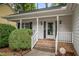 Inviting front entrance with brick steps and white railings, complemented by a well-manicured green bush at 2629 Hiking Trl, Raleigh, NC 27615
