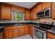 Kitchen showcasing stainless steel appliances, granite countertops, wooden cabinets and an oven range at 2629 Hiking Trl, Raleigh, NC 27615