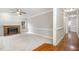 Spacious living room with a brick fireplace, plush carpet, and abundant natural light from a window at 2629 Hiking Trl, Raleigh, NC 27615