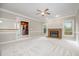 Bright living room featuring a fireplace, ceiling fan, and an open layout, adjoining a kitchen area at 2629 Hiking Trl, Raleigh, NC 27615
