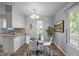 Cozy dining area featuring a table with white chairs, a modern chandelier, and plenty of natural light at 2704 Shaftsbury St, Durham, NC 27704
