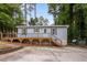 Charming single-story home with a light blue exterior, wood deck, and a well-maintained front yard surrounded by trees at 2704 Shaftsbury St, Durham, NC 27704