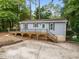 Charming home featuring a wooden deck, light blue siding, and mature trees surrounding the property at 2704 Shaftsbury St, Durham, NC 27704