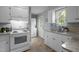 Well-equipped kitchen with white appliances, granite countertops, and convenient laundry area at 2704 Shaftsbury St, Durham, NC 27704