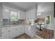 Bright kitchen featuring white cabinets, granite countertops, and a view into the dining area at 2704 Shaftsbury St, Durham, NC 27704