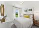 Bright bedroom featuring white bedding, stylish decor, and a large window offering a scenic outdoor view at 2808 Kempthorne Rd # 61, Cary, NC 27519