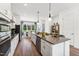 Modern kitchen featuring white cabinets, a large island, stainless steel appliances, and an adjacent dining area at 2808 Kempthorne Rd # 61, Cary, NC 27519