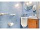Commercial-style bathroom featuring bright blue tiled walls, and wall-mounted sink and fixtures at 2817 Henslowe Dr, Raleigh, NC 27603