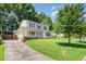 Two-story home with white siding, black shutters, covered porch, and a long driveway leading to the property at 2817 Henslowe Dr, Raleigh, NC 27603