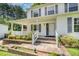 Inviting covered front porch with white railings, brick accents, and a charming entryway to the home at 2817 Henslowe Dr, Raleigh, NC 27603