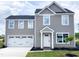 Charming two-story home featuring a white garage door, inviting entrance, and landscaped front yard at 302 Rosewood Dr, Sanford, NC 27330