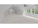 Bright attic with recessed lights, fan, and two windows, offering versatile potential as a bonus room at 3104 Whitehart Ln, Apex, NC 27539