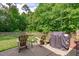 Backyard patio area featuring wooden chairs and a barbecue grill at 3104 Whitehart Ln, Apex, NC 27539