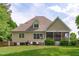 View of the home's backyard with a screened porch, lawn and mature landscaping at 3104 Whitehart Ln, Apex, NC 27539