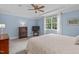 Spacious bedroom featuring a ceiling fan, large windows, wood furnishings, and neutral carpeting at 3104 Whitehart Ln, Apex, NC 27539