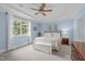 Comfortable bedroom with blue walls, large windows, a ceiling fan, and neutral carpeting at 3104 Whitehart Ln, Apex, NC 27539