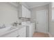 Practical laundry room featuring white appliances, ample cabinet space, and a utility sink at 3104 Whitehart Ln, Apex, NC 27539